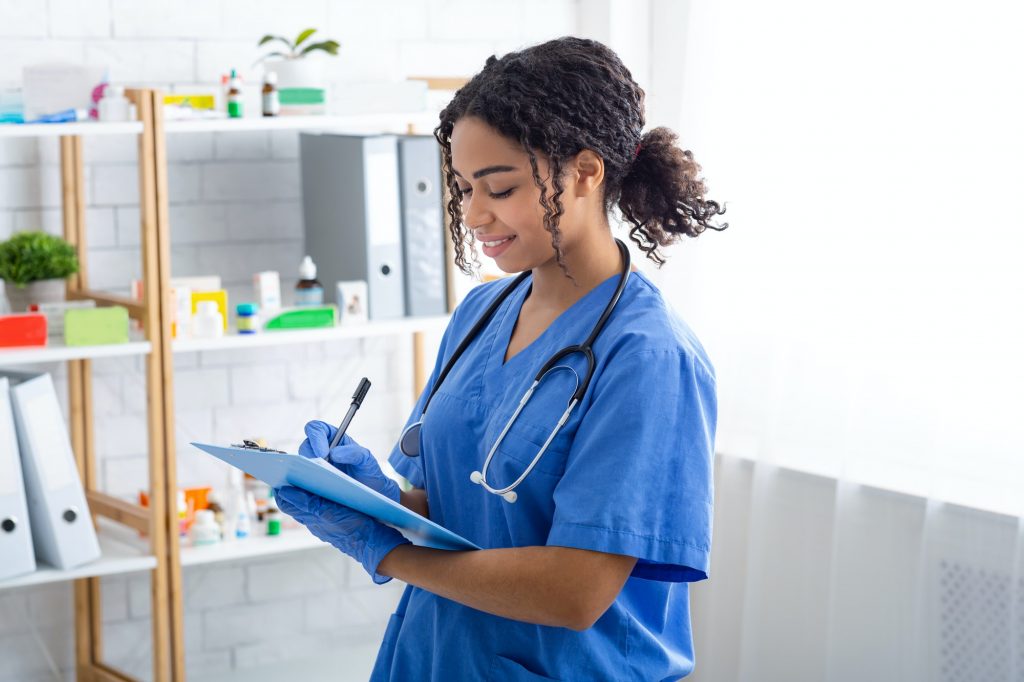 Happy veterinary doctor writing on clipboard at animal clinic